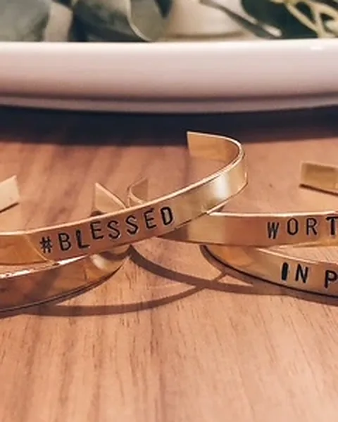 Close-up of brass cuffs stamped #Blessed and Worthy